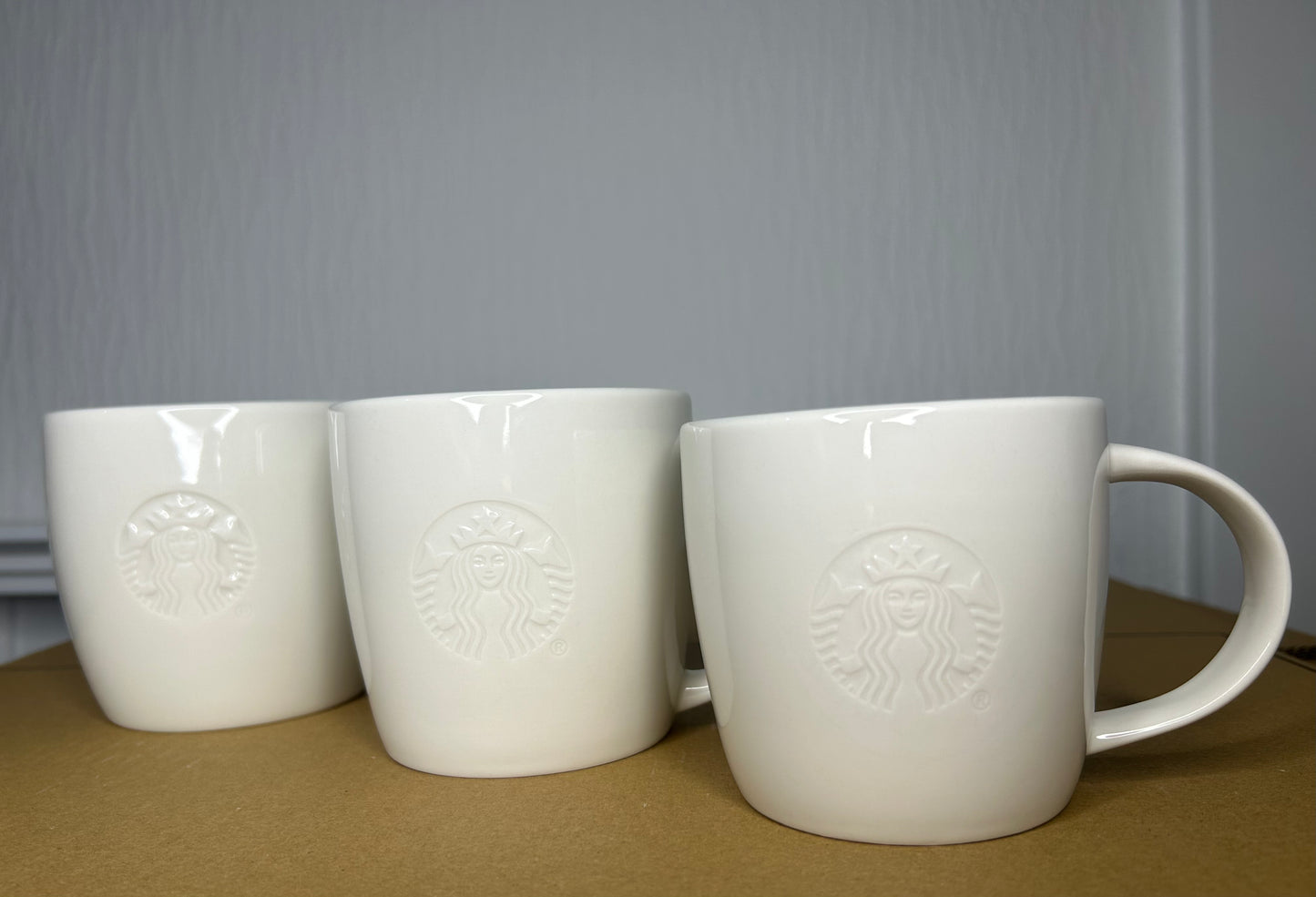 Side profile of Starbucks White Grande Mug with embossed logo