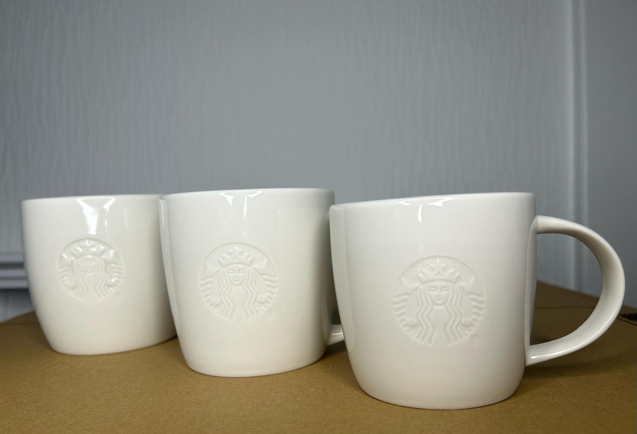 Side angle of Starbucks White Tall Mug with embossed logo