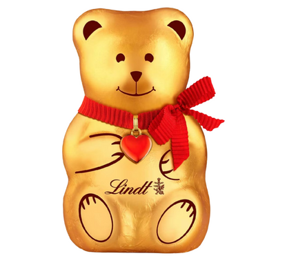 Gold teddy bear-shaped chocolate with a red ribbon and heart pendant, branded 'Lindt'