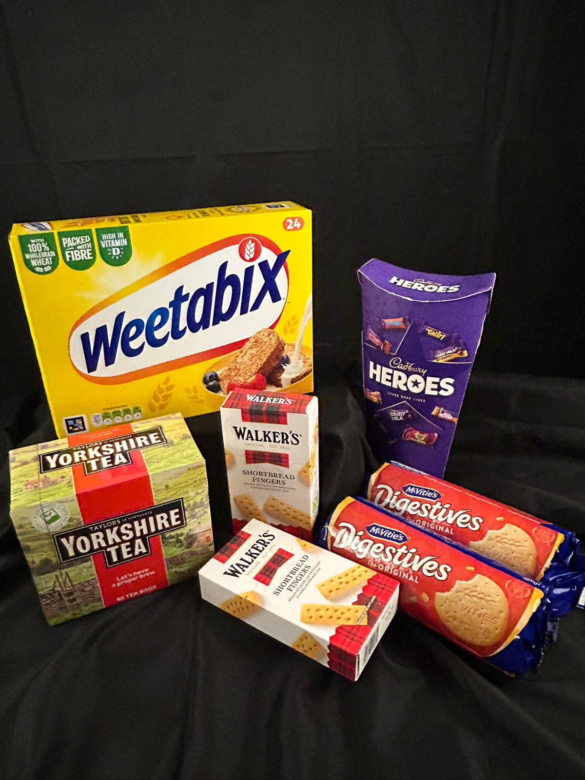 Assorted food products including Weetabix, Heroes chocolate bars, Yorkshire Tea, Walker's shortbread Fingers , and Nestle Digestives .
