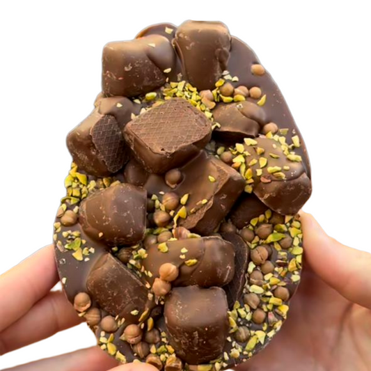 Chocolate candy shaped like a shark cage with nuts and chocolate pieces on a white background.