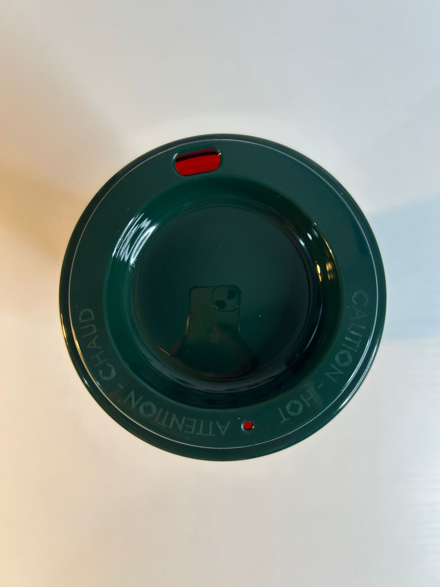 Green plastic lid with text on a white background