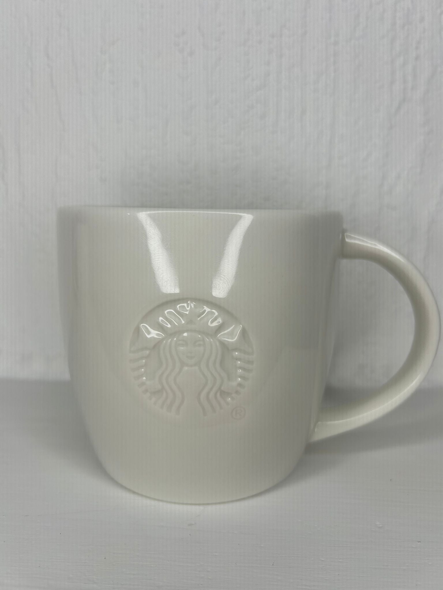 Front view of Starbucks classic white tall mug