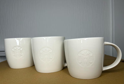 Side angle of Starbucks White Tall Mug with embossed logo