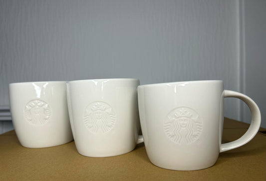 Side angle of Starbucks White Tall Mug with embossed logo